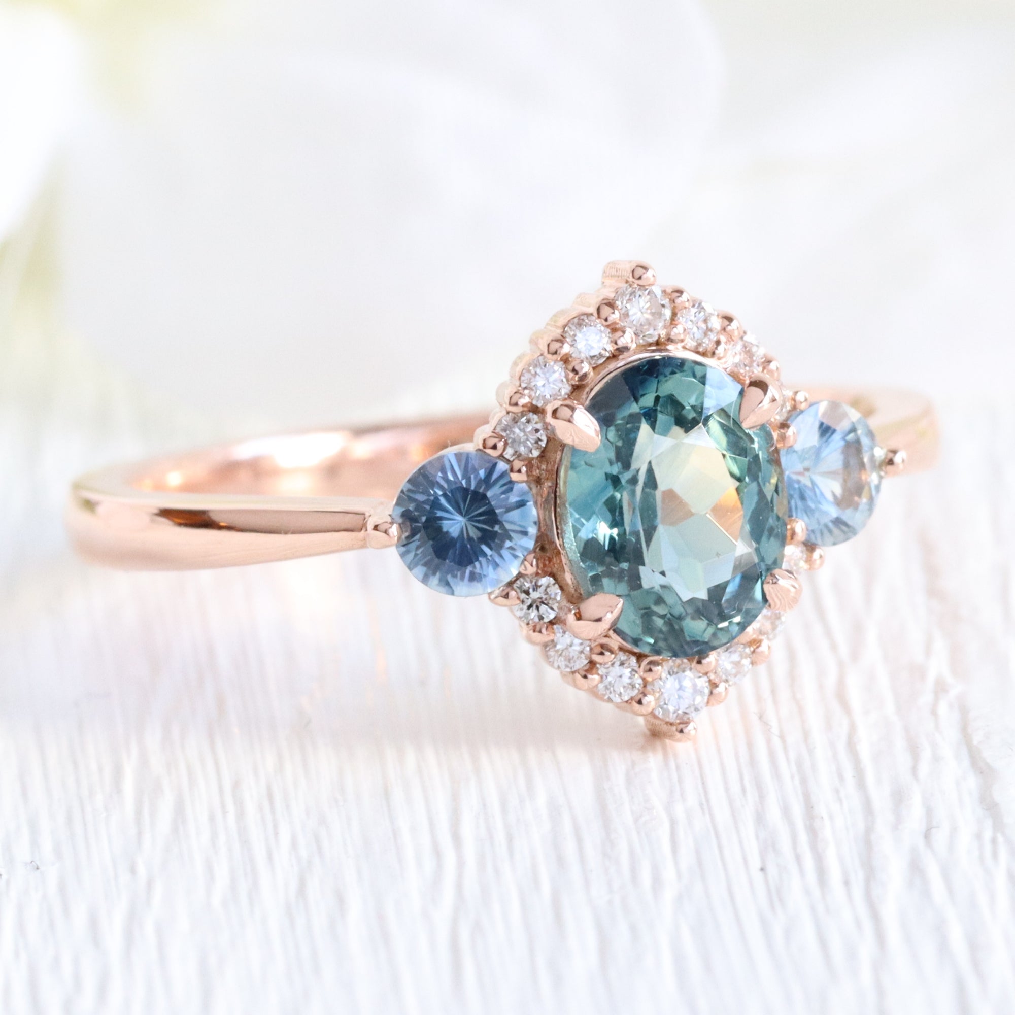 Unique teal blue sapphire ring rose gold diamond halo 3 stone ring la more design jewelry