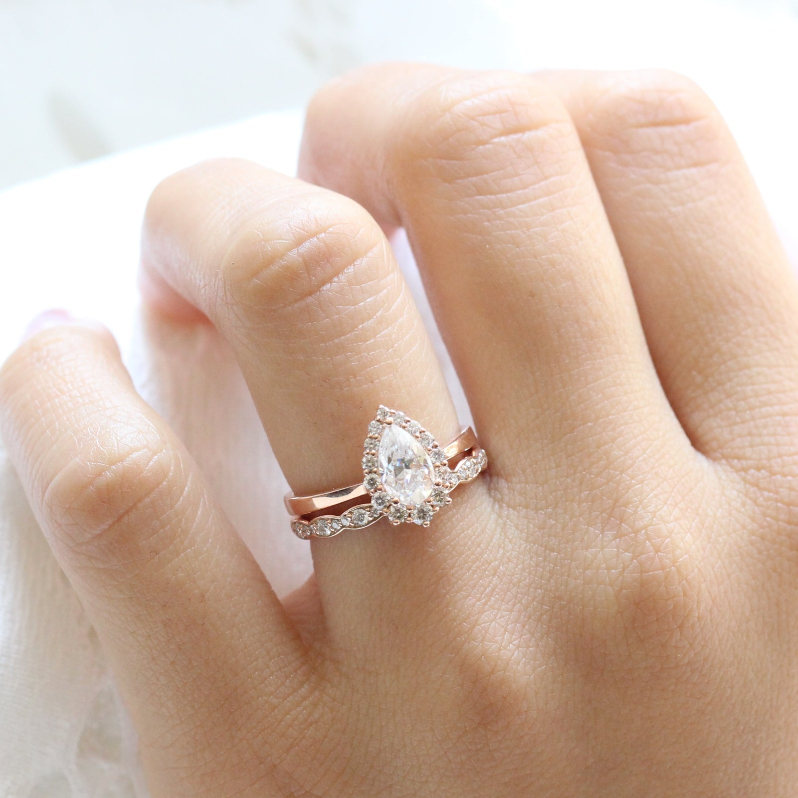 pear moissanite engagement ring rose gold halo diamond ring and matching diamond wedding band by la more design jewelry