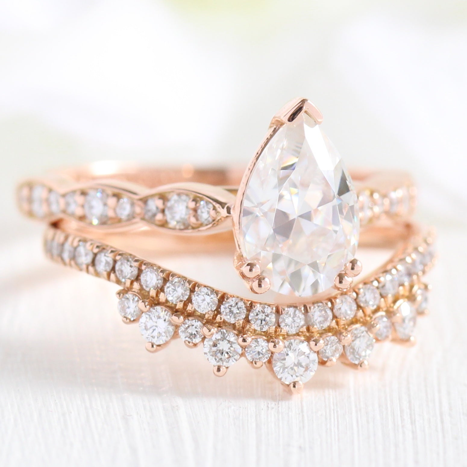 Solitaire pear moissanite ring and curved crown diamond wedding band in rose gold bridal set by la more design