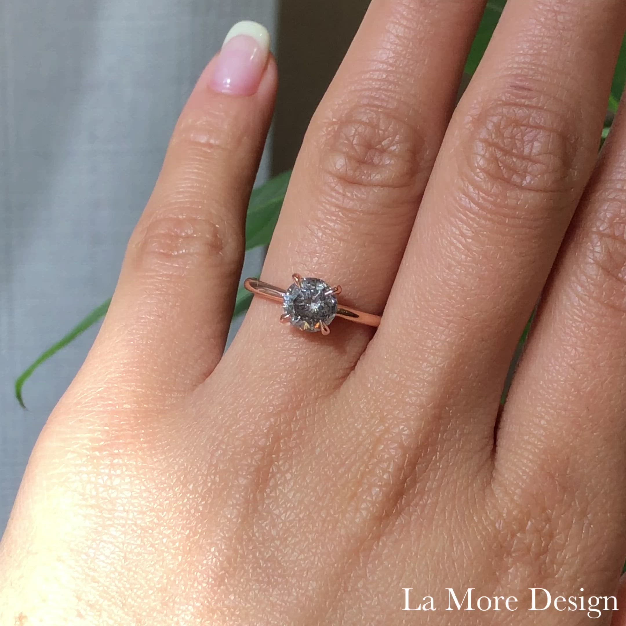 This stunningly gorgeous grey diamond engagement ring features a large 1.62 carat round cut natural salt and pepper diamond set in a 14k rose gold flat set low profile solitaire ring setting that lays flat perfectly on top of your finger for comfortable wear. Adore your love with this large one and half carat diamond ring!